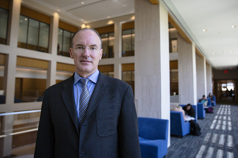 Thomas Craemer, a professor in the Department of Public Policy, poses in the hallway of the UConn Hartford campus.