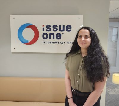 An intern in front of Issue One: Fix Democracy First sign
