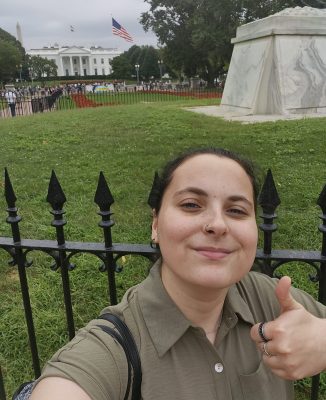 A woman poses in front of the White House