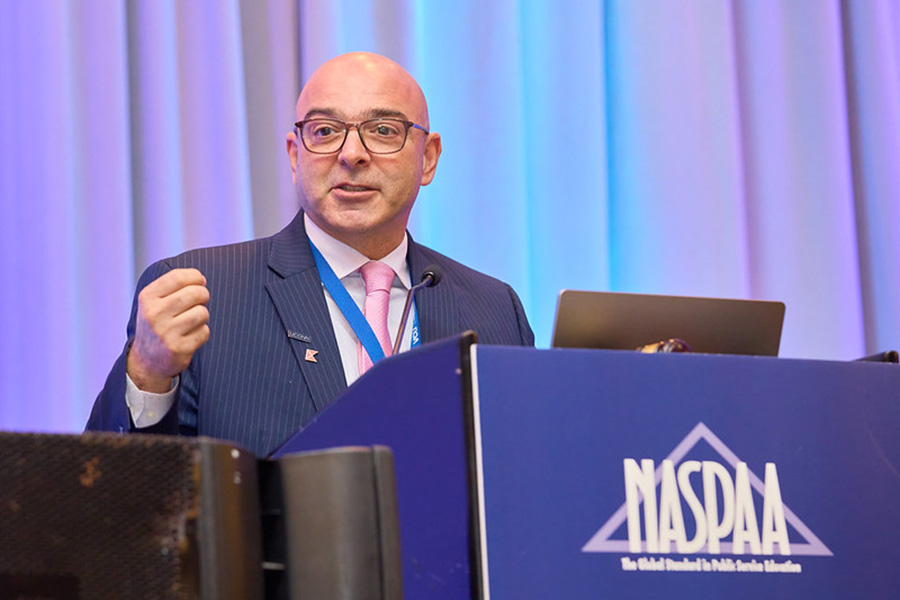 Mohamad Alkadry speaks at a podium with the NASPAA logo. 
