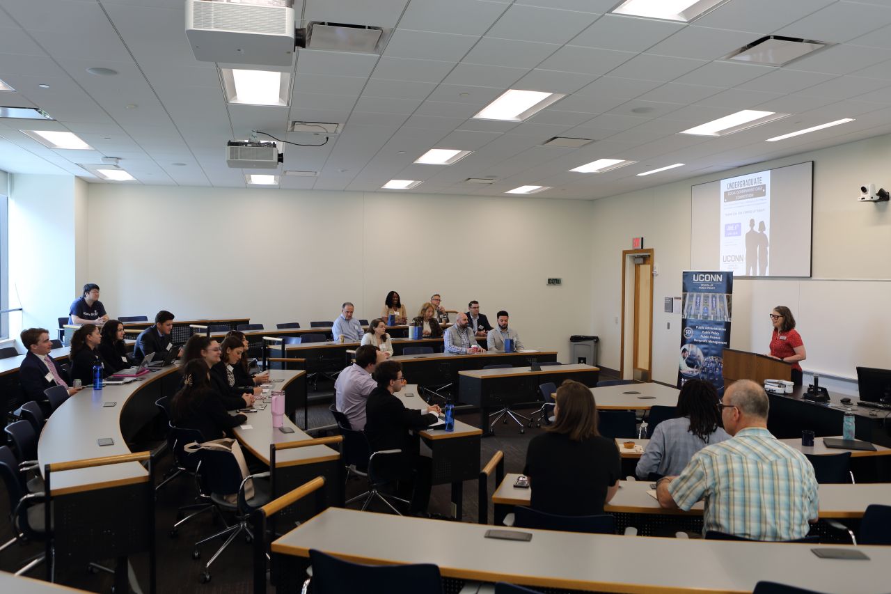 Photo of Dr. Angela Eikenberry of UConn, speaking to undergraduate students competing in UConn SPP Local Government Management case competition, and other public service professional guests, in June 2026.