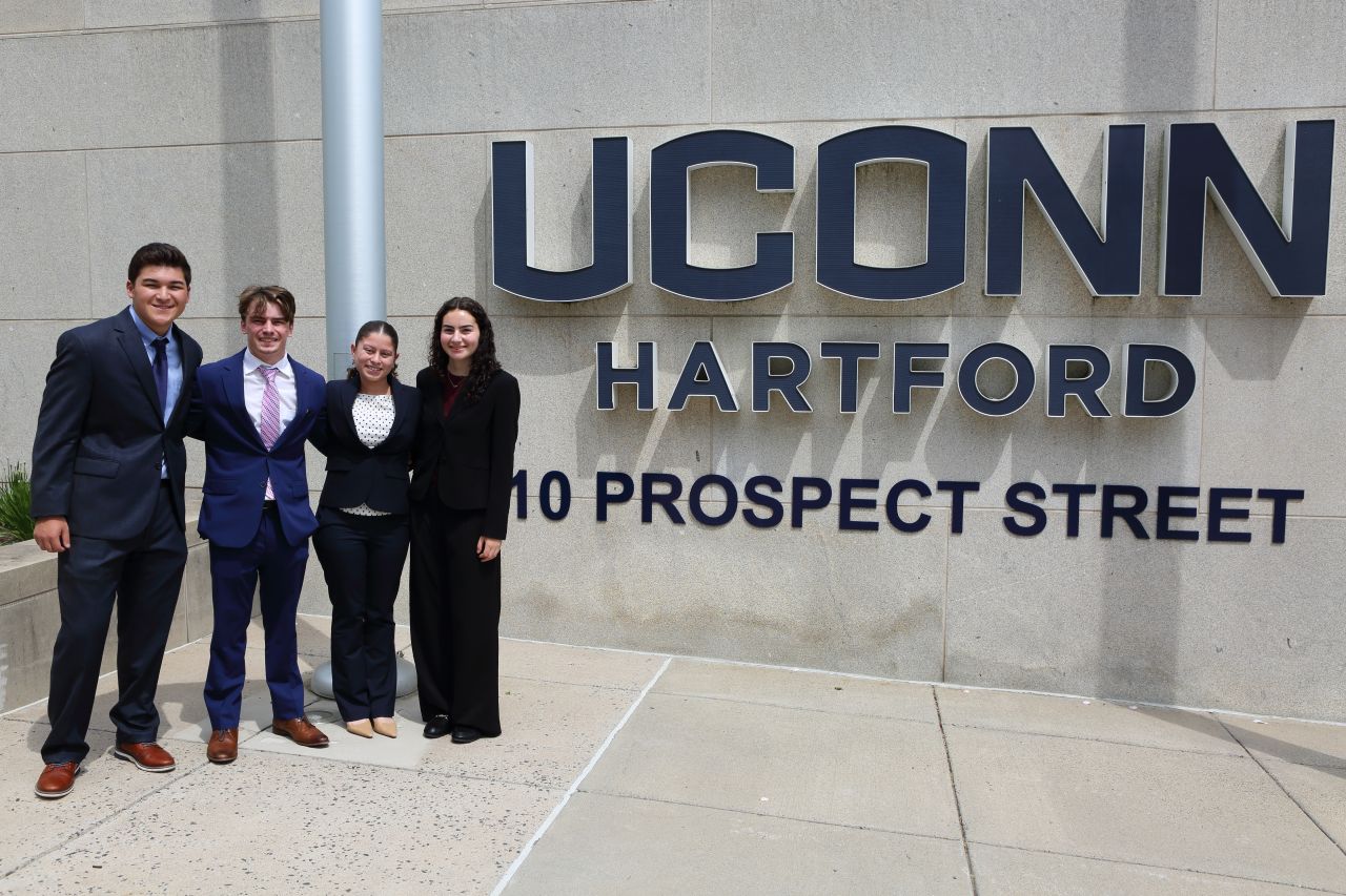 Image of winning undergraduate team from UConn SPP case competition in June 2026, standing in front of the UConn Hartford campus sign.