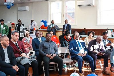Community members sitting in chairs while listening to opening remarks. 